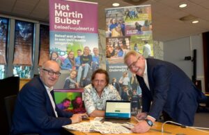 Wethouder Jo Schlangen (links) stuurt in het bijzijn van Frank Ramakers (midden) en Bert Schroën (rechts) de kwaliteitsstukken voor Het Martin Buber naar Den Haag.